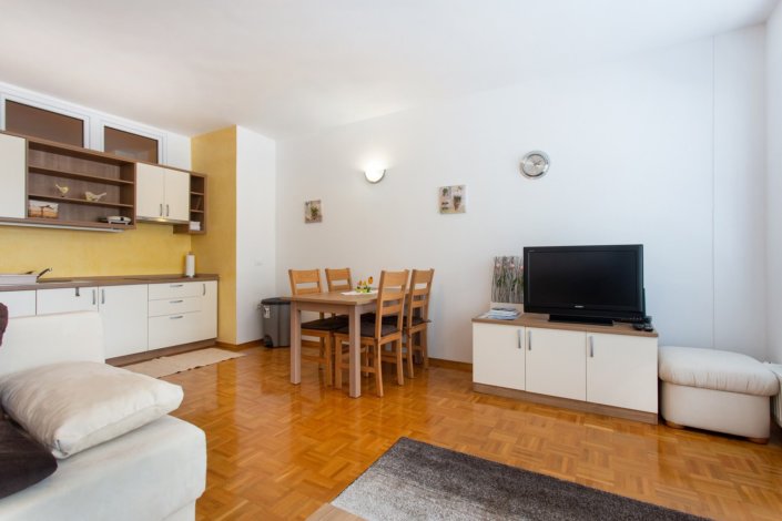 Dnevni prostor z jedilno mizo in kabelskim TV-jem.